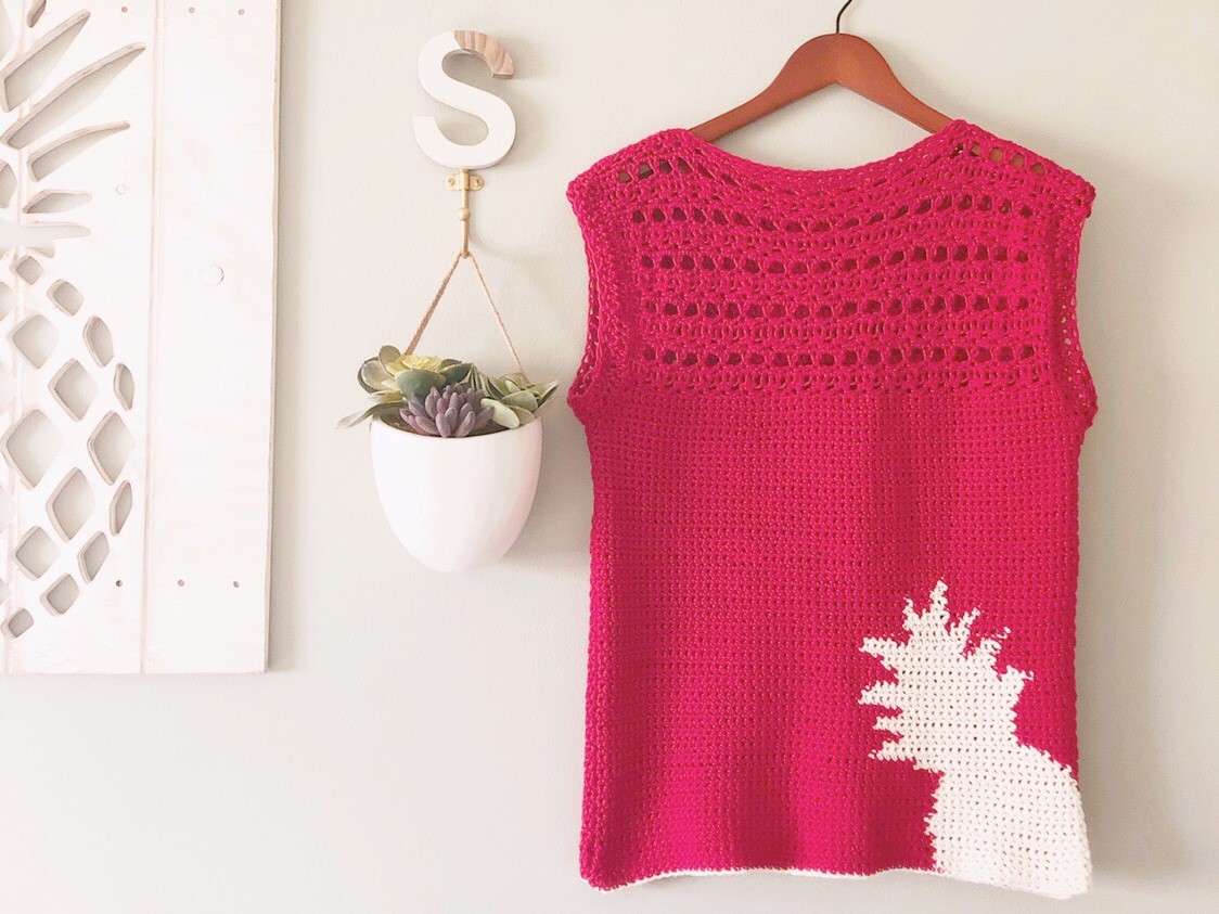 Red crochet top with cream pineapple color work in the bottom right corner with a lacy, open yoke and cap sleeves shown in size small