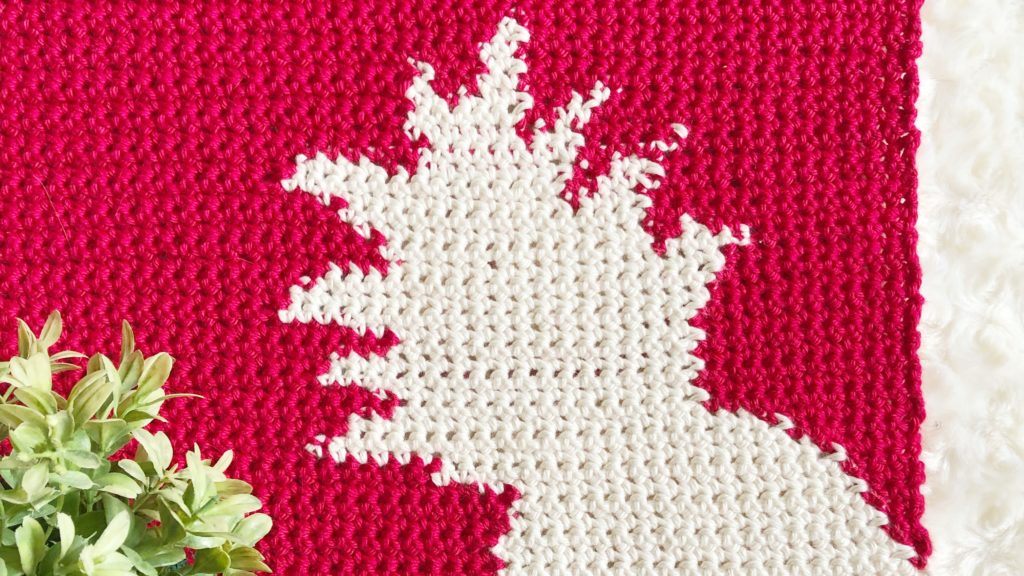 Red crochet panel with cream pineapple color work in the bottom right corner